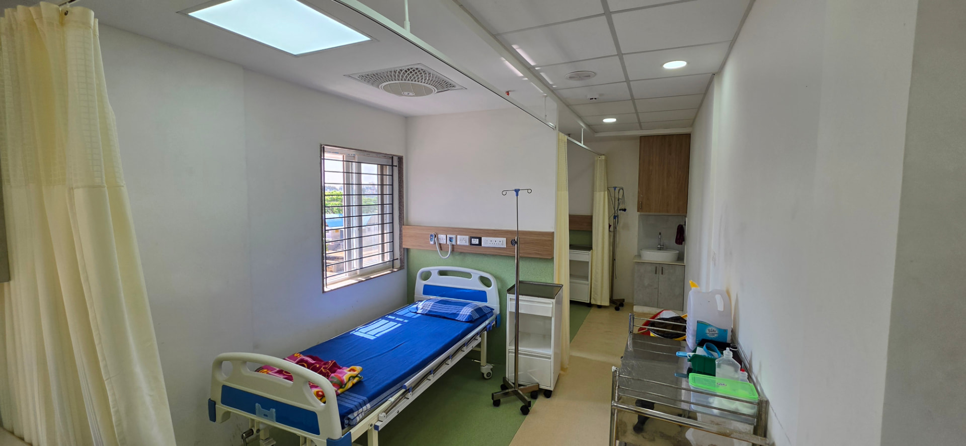 Private day-care room with a single bed, IV stand and attached washroom